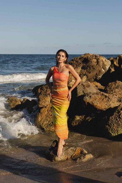 Model in one-shoulder cover up dress at beach