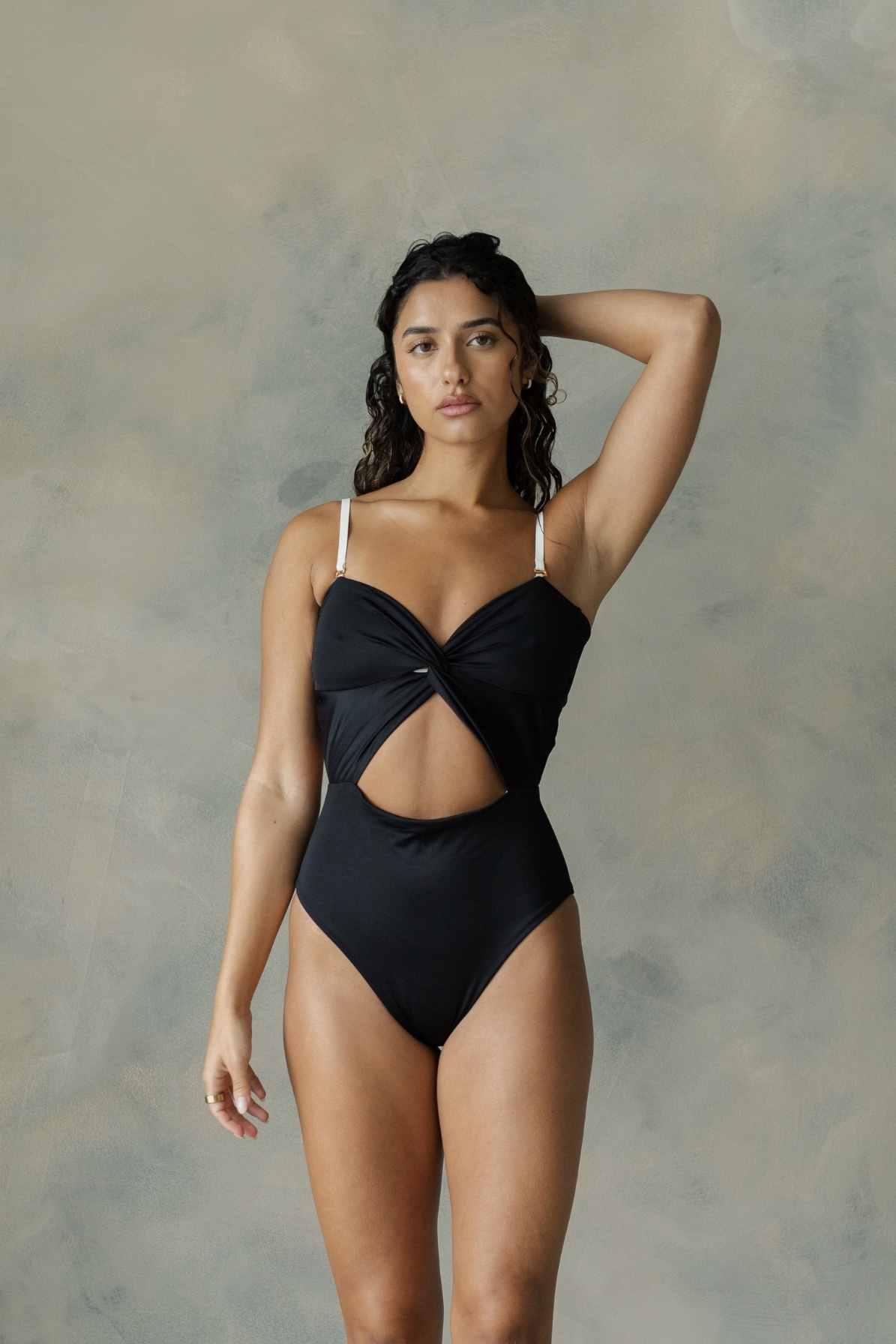 Model wearing black one piece swim