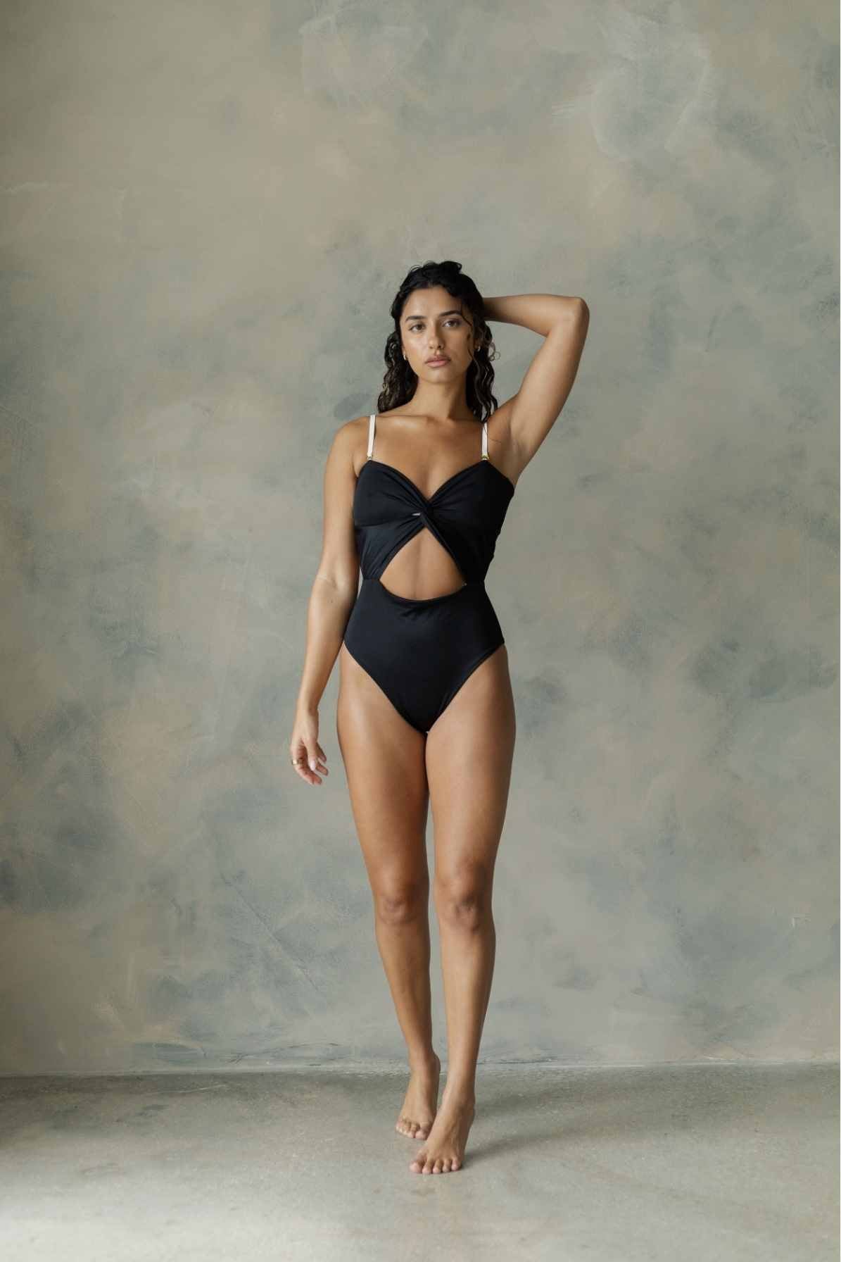 Full view of model wearing one-piece black swim