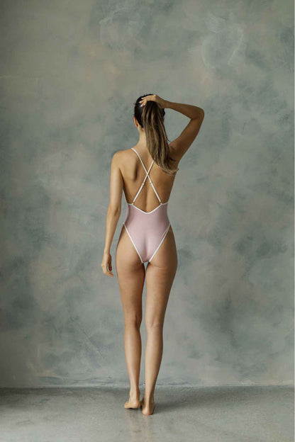 Backview of model in blush swimsuit